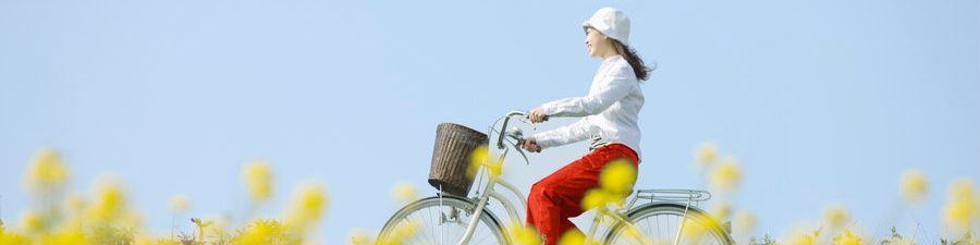 Une jeune femme fait une balade à vélo dans un champ en fleurs en été
