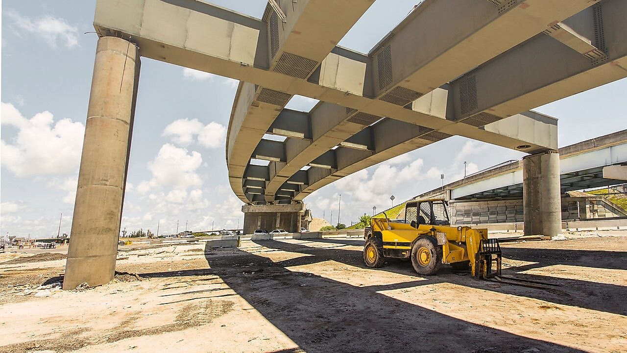 un camion pelleteuse sous un pont aérien qui est en cours de construction