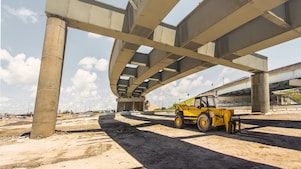 un camion pelleteuse sous un pont aérien qui est en cours de construction