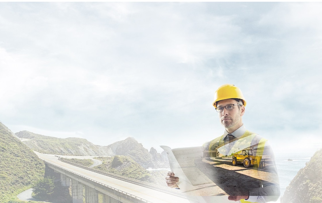 Un travailleur portant un casque jaune transposé sur un fond de route dans des montagnes