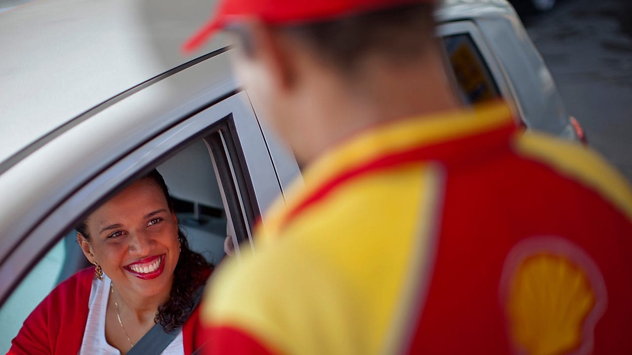 Cliente souriant à un champion de service Shell 