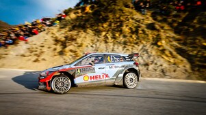 Une voiture de rallye en dérapage sur une route du championnat du monde des rallyes