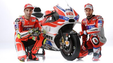 Deux pilotes Ducati 2016 assis à côté d'une moto Ducati