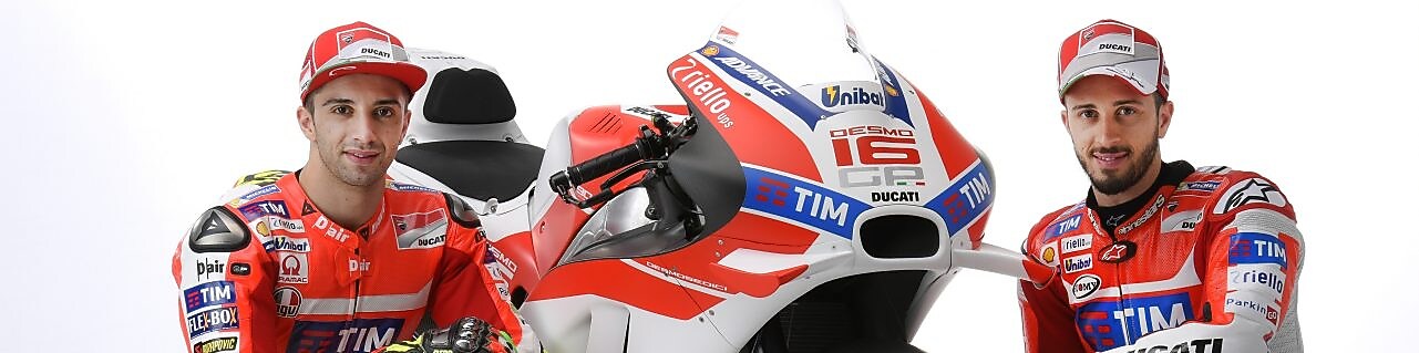 Deux pilotes Ducati 2016 assis à côté d'une moto Ducati