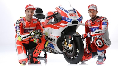 Deux pilotes Ducati 2016 assis à côté d'une moto Ducati