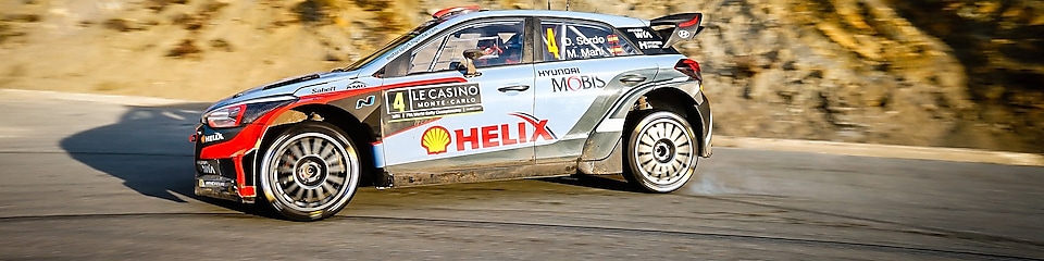 Une voiture de rallye en dérapage sur une route du championnat du monde des rallyes
