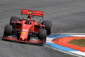 Pilote Ferrari F1 versant de l&rsquo;huile Shell Helix Ultra dans le moteur d'une voiture