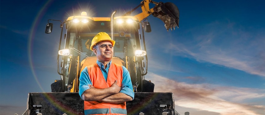 travailleur debout en face de cette pelleteuse