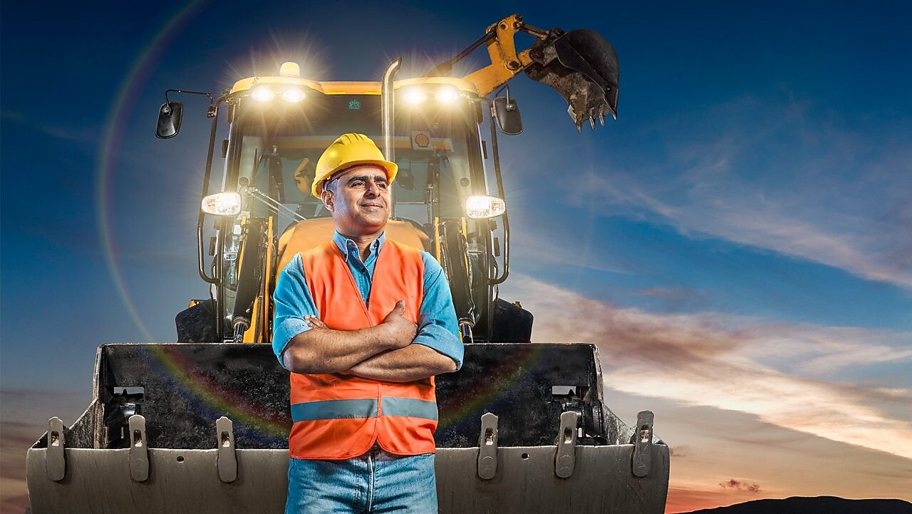 travailleur debout en face de cette pelleteuse