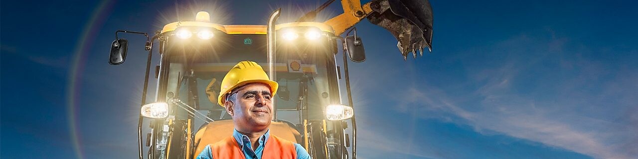 travailleur debout en face de cette pelleteuse