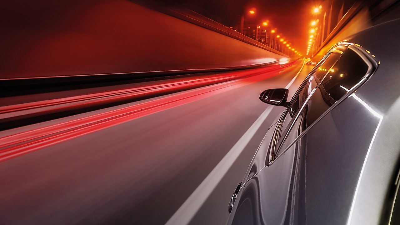 Voiture qui roule dans un tunnel éclairé
