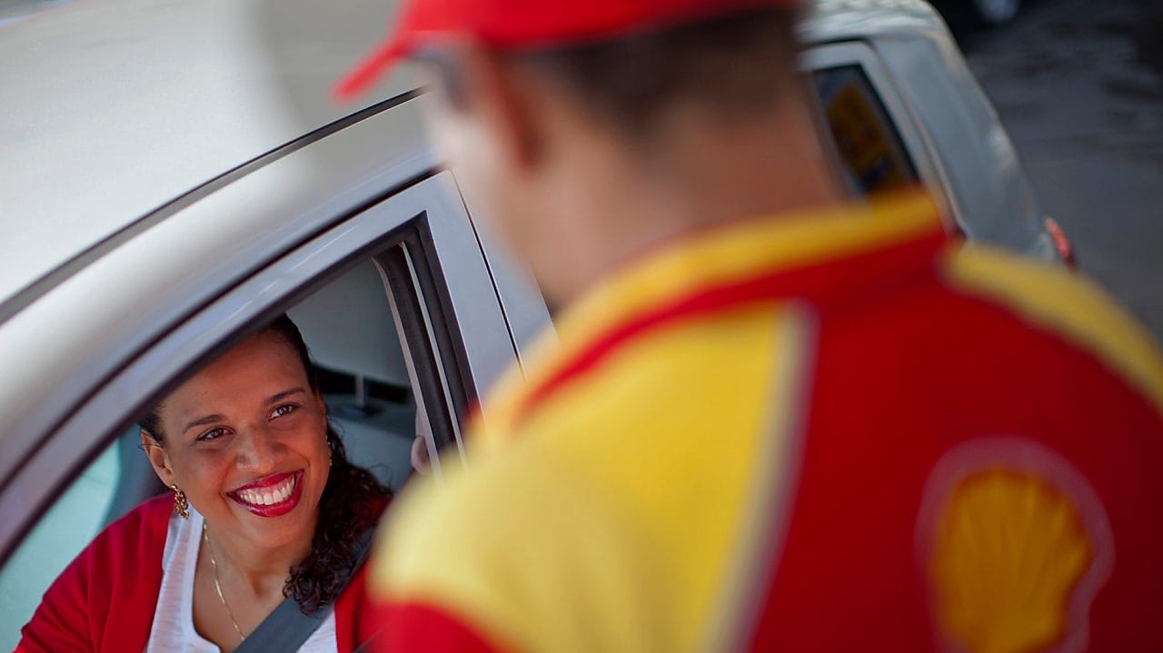 Cliente souriant à un champion de service Shell