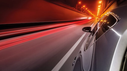 Voiture qui roule dans un tunnel éclairé