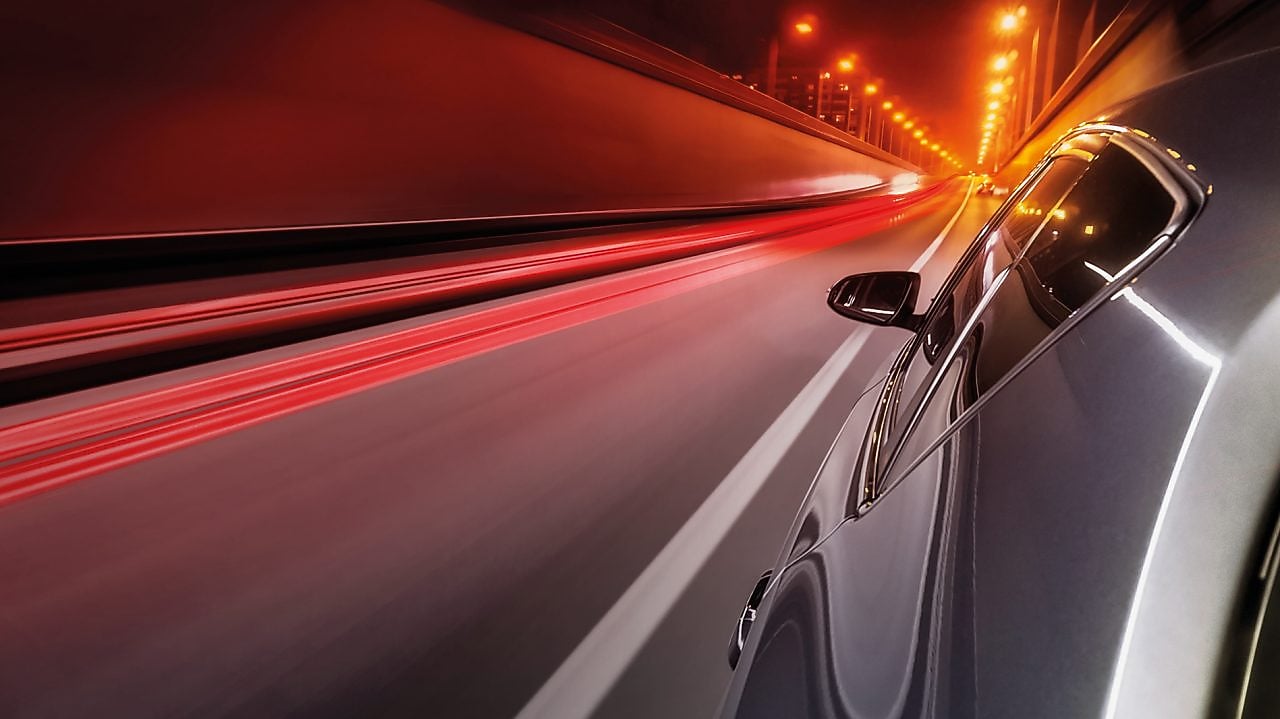 Voiture qui roule dans un tunnel éclairé