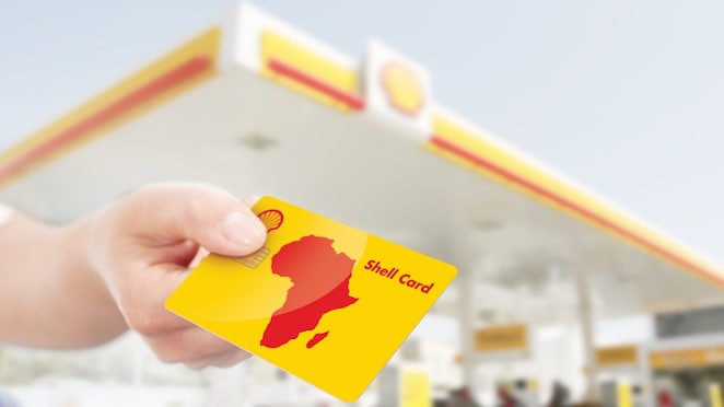 Shell Card tendue par quelqu'un dans une station-service Shell